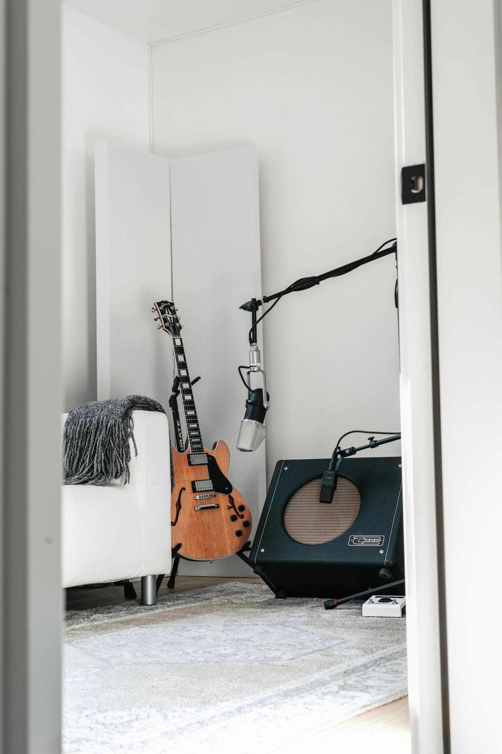 Guitar, studio microphone, and amplifier prepared for recording